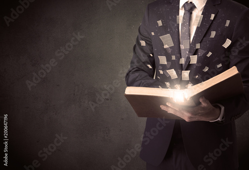 Man holding a book with document symbols around.