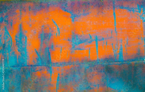 The texture of an orange and blue paint on metal
