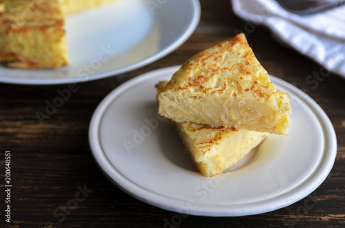 Homemade tortilla, typical Spanish omelette made with eggs and potatoes. Traditional Spanish tapas or snack served in white plate.