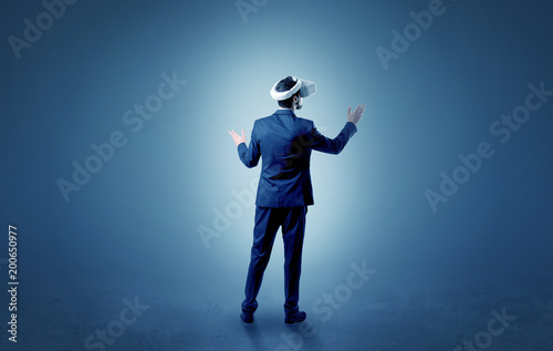 Businessman wearing vj glasse in an empty room with no wallpaper