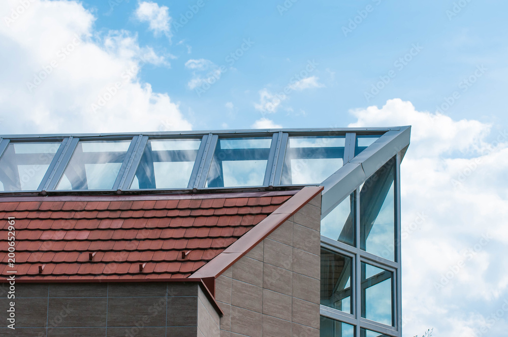 Modern buildings glass roof top close up, beautiful blue sky background with white clouds.