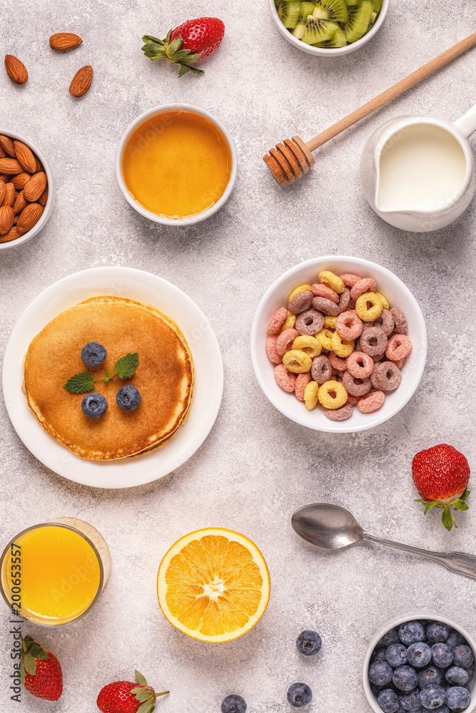 Breakfast with colorful cereal rings, pancakes, fruit, milk, juice. Breakfast with colorful cereal rings, pancakes, fruit, milk, juice.