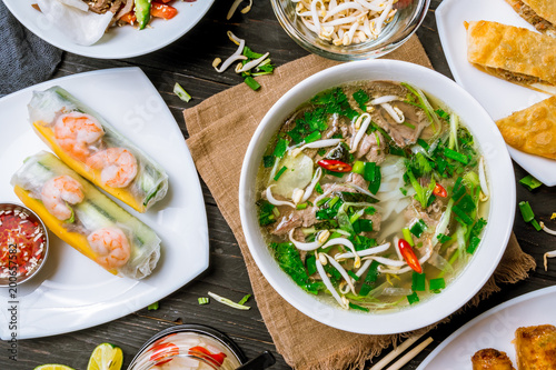 Assorted asian dinner, vietnamese food. Pho ga, pho bo, noodles, spring rolls photo