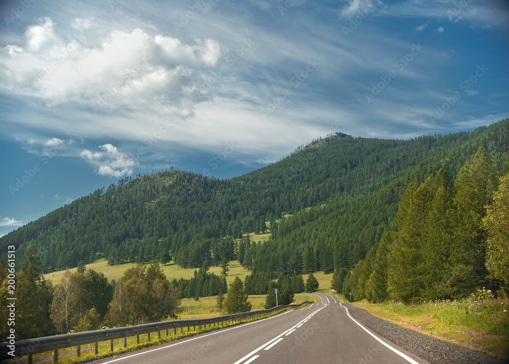 Fototapeta premium highway through hills and clouds on sky
