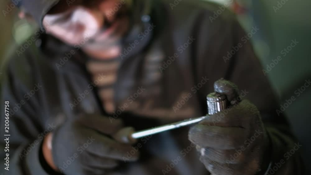 The mechanic in dirty auto repair shop repairs the car repairs