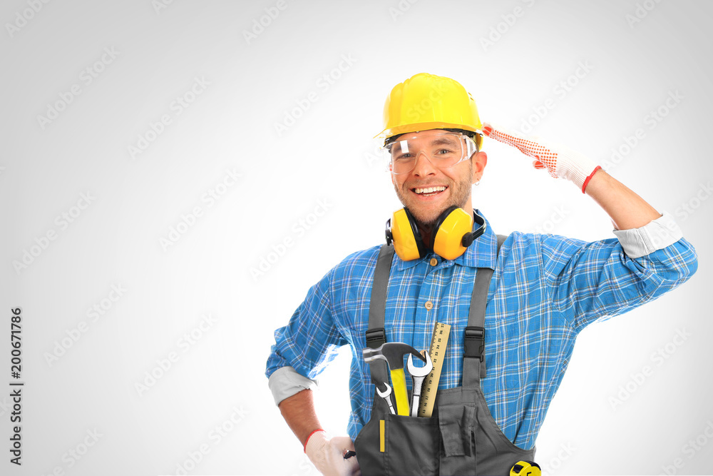 Builder in yellow helmet, protective glasses and working clothes Builder in yellow helmet, protective glasses and working clothes