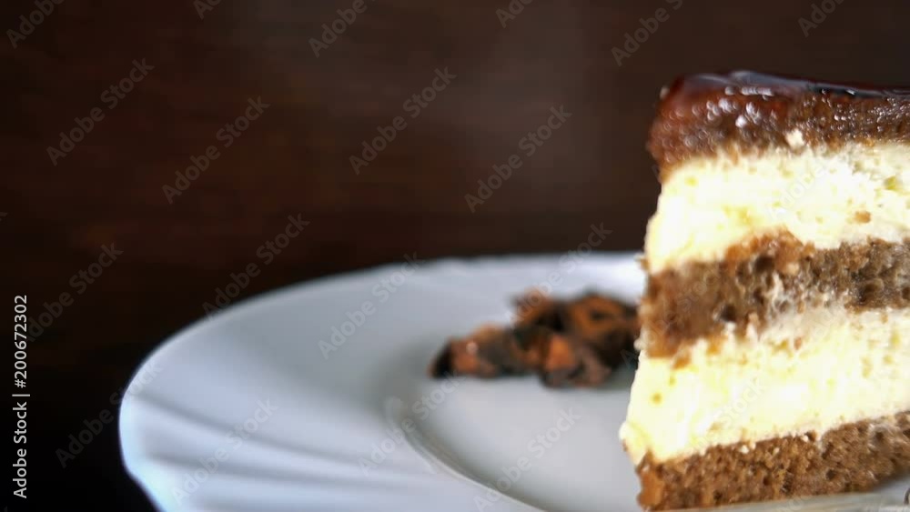 Slice of chocolate cake on a white plate, rotating, 4K