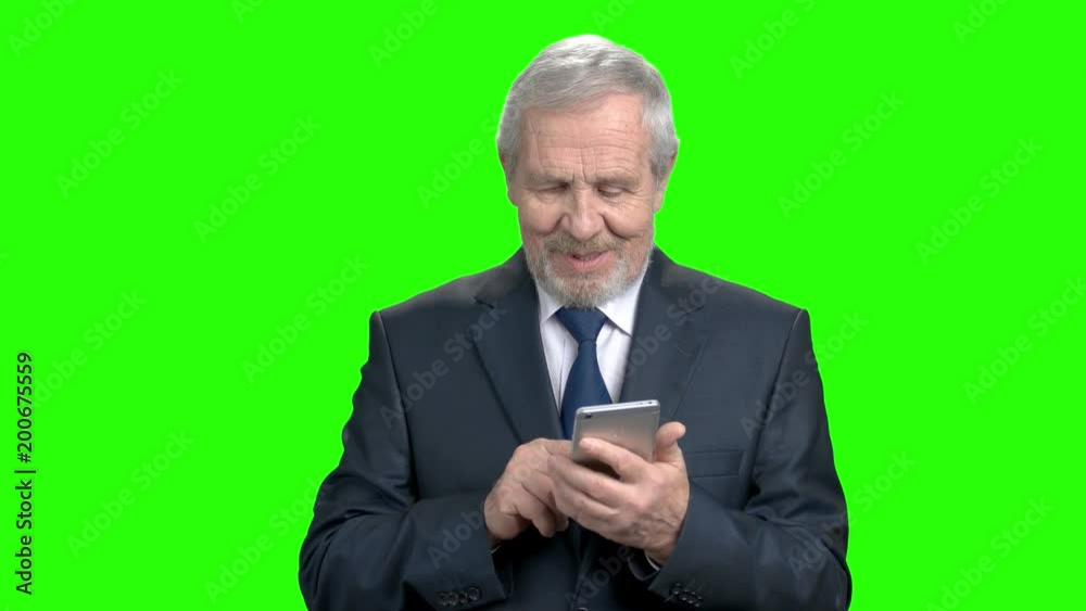 Smiling businessman typing a message on smartphone. Happy elderly businessman with modern mobile gadget, Alpha Channel background. Smiling businessman typing a message on smartphone. Happy elderly businessman with modern mobile gadget, Alpha Channel background.