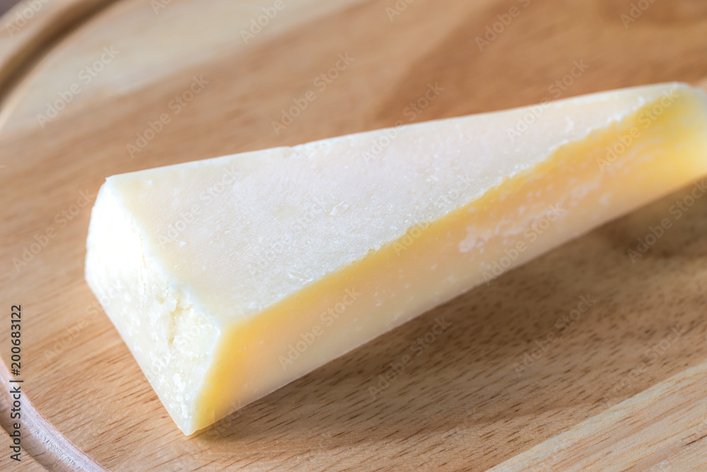Grana Padano cheese on the wooden board