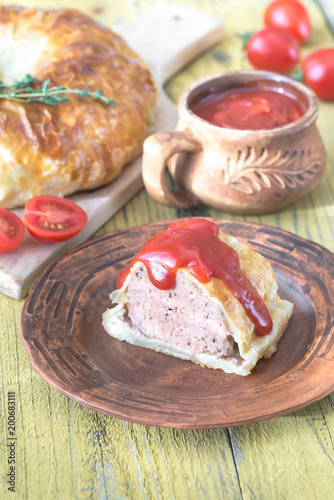 Portion of beef Wellington with tomato sauce