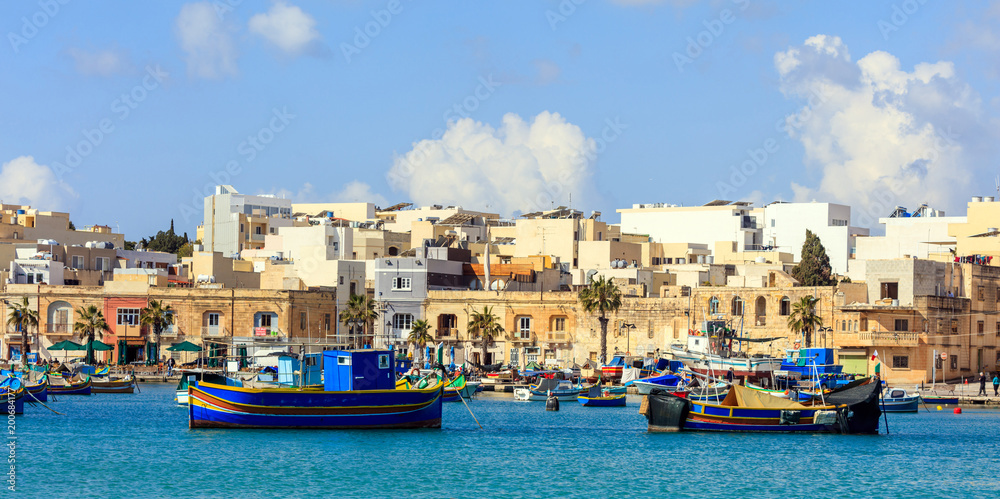 Marsaxlokk fishermen village in Malta. Traditional colorful boats at the port of Marsaxlokk