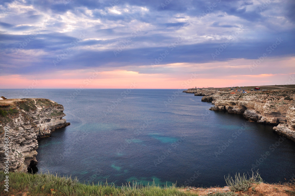 High cliffs of the sea shore. The evening landscape by the sea.