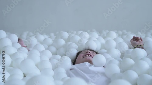 Kid having fun in a pool with balls photo