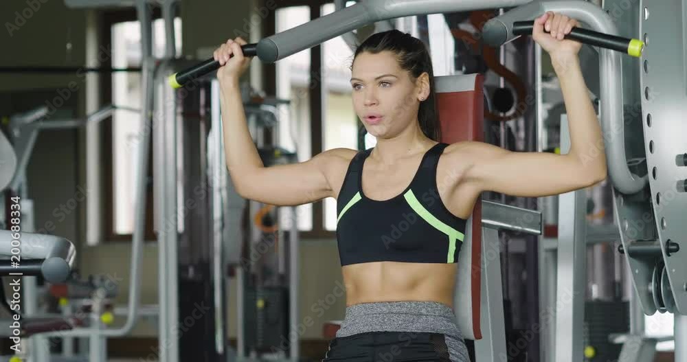 A beautiful smiling woman trains at the gym with both sports equipment and free body to keep fit and be toned. Concept of: training, wellness, sport, gym, diet. A beautiful smiling woman trains at the gym with both sports equipment and free body to keep fit and be toned. Concept of: training, wellness, sport, gym, diet.
