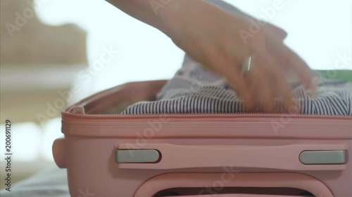 Female hands packing suitcase with clothes, 4k