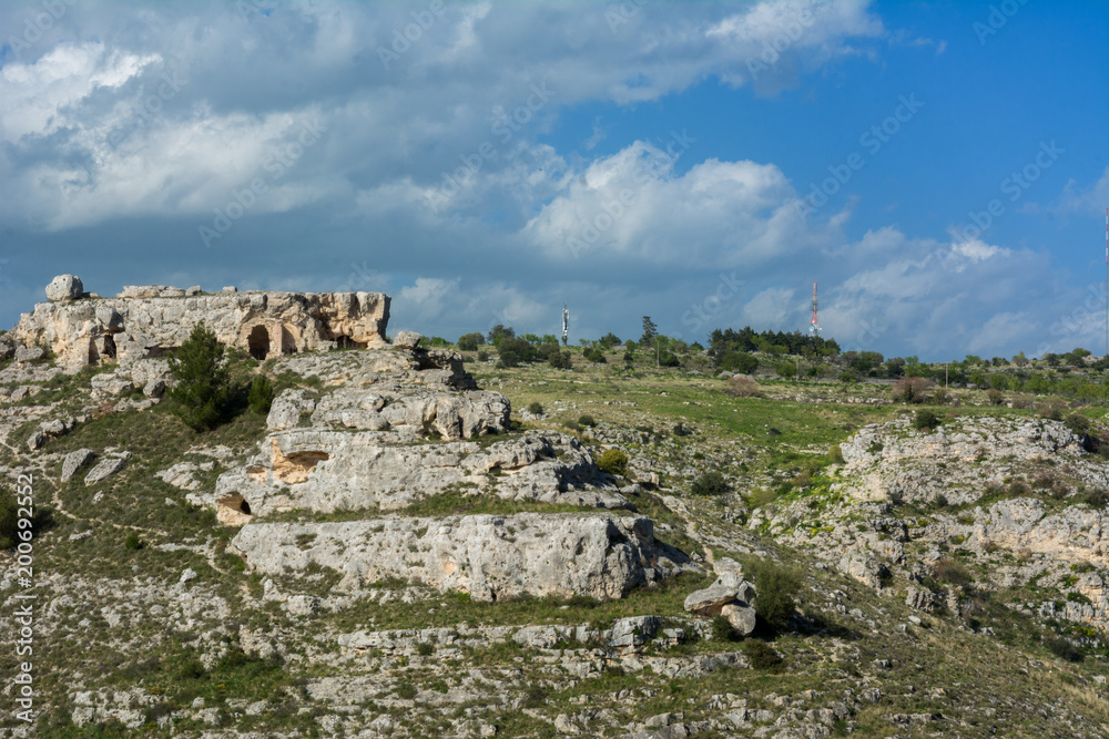 Horizontal View of some Prehistoric Caves in the Gravina of the Sassi of Matera on Blue Sky Background. Matera, South of Italy