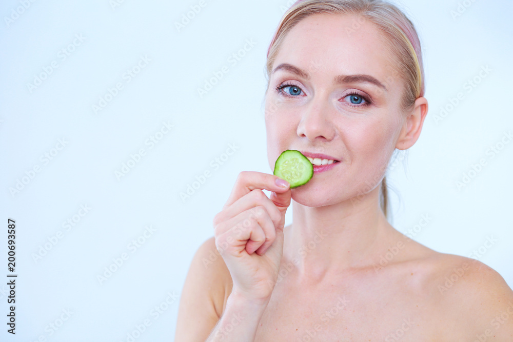 Young beautiful woman with cucumber slices on white background. Young beautiful woman with cucumber slices on white background.