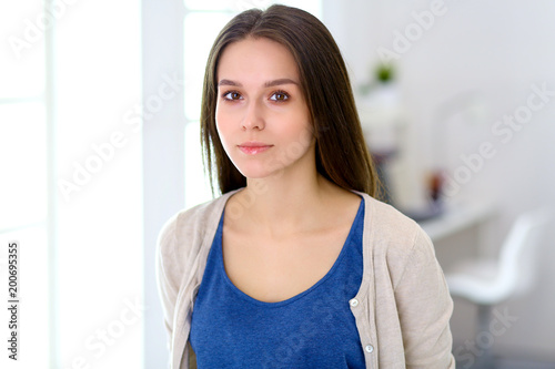 Attractive young woman standing in white studio