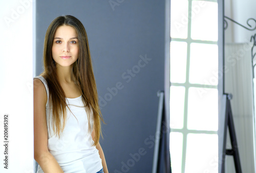 Young woman looking herself reflection in mirror at home Free Download Young woman looking herself reflection in mirror at home - GFXLoad