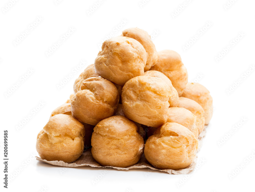 Homemade  profiteroles on baking paper isolated on white