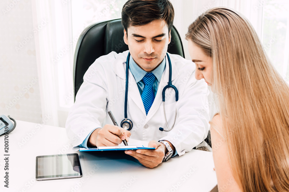 Doctor consulting and check up information with female patien on doctors table in hospital.healthcare and medicine Doctor consulting and check up information with female patien on doctors table in hospital.healthcare and medicine