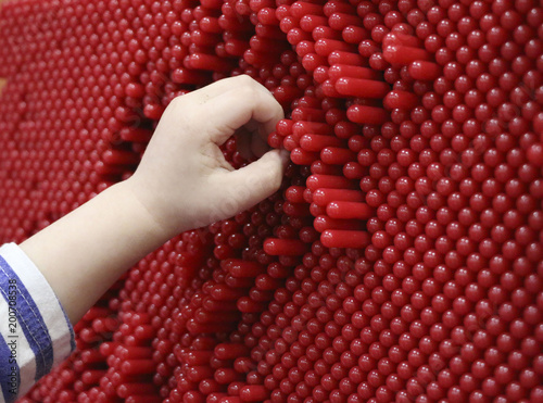 children's hands and pinskreen. the child is playing with the contact screen. children's hands are pressed onto the plastic pins on the interactive panel and leave prints. photo