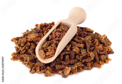 Propolis granules in a wooden scoop. Isolated on white background. Apitherapy.