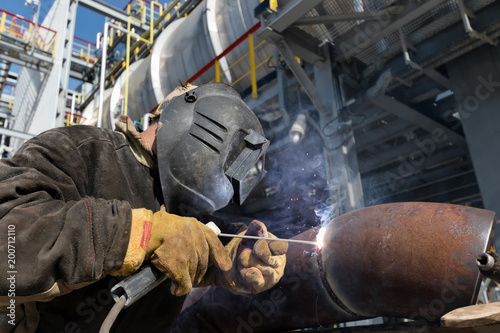 Welding works on metal heat exchanger using manual arc welding