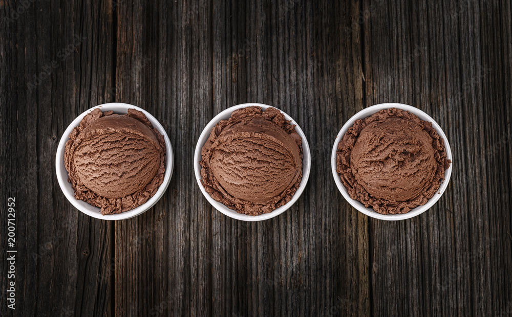 Chocolate ice cream with bowl on wooden background Chocolate ice cream with bowl on wooden background