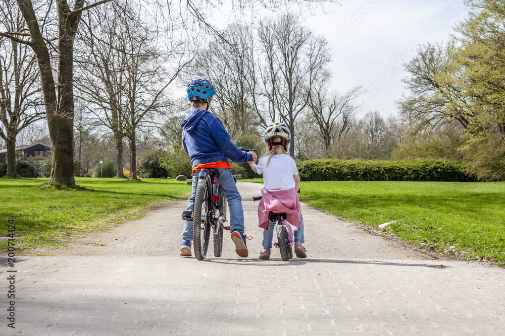 Boy and girl holding hands while on their bicycles Boy and girl holding hands while on their bicycles
