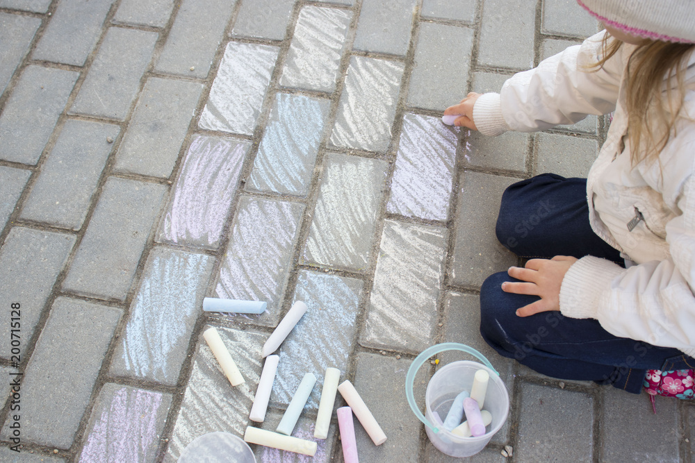 little girl draws a chalk, paints road tile little girl draws a chalk, paints road tile