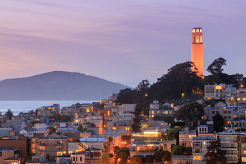 Fototapete San Francisco Coit Tower leuchtet orange in Anerkennung der San Francisco Giants. Genommen von einer im Stadtzentrum gelegenen Gebäudedachspitze. San Francisco, Kalifornien, USA.  © Yuval Helfman