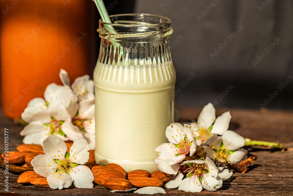 Almond with jar of almond milk and white flowers Almond with jar of almond milk and white flowers