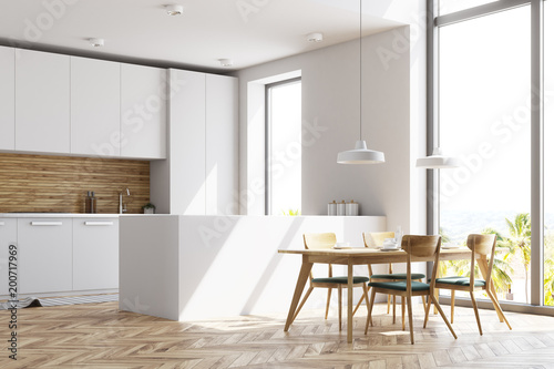 White and wooden kitchen with a table, side view