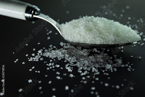 Sugar on spoon in black background