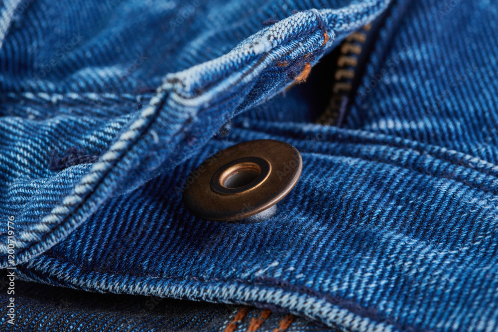 Denim jeans texture background with torn. The texture of the colored cotton fabric. Stitched texture jeans background. Fashion jeans button. Pocket and rivet on jeans. Fiber and fabric structure. Denim jeans texture background with torn. The texture of the colored cotton fabric. Stitched texture jeans background. Fashion jeans button. Pocket and rivet on jeans. Fiber and fabric structure.