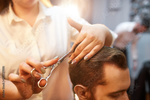 Young handsome bearded man visiting barber shop. Barber concept.