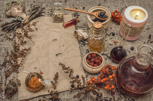Herbal medicine background. Alternative medicine. Dry curative herbs and wild berry essential oil and blank crumpled paper page sheet (recipe, doctor prescription) on burlap sackcloth background. © Dmitriy