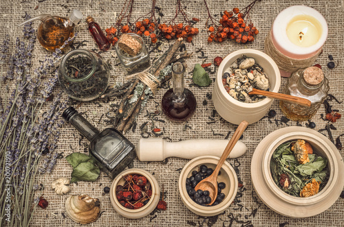 Herbal medicine concept. Alternative medicine. Dry wild rowan berry and apple berry, lavender flowers and other curative herbs essential oil on burlap sackcloth background. © Dmitriy