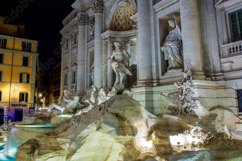 Horizontal View of the Fontana di Trevi Illuminated By Green and Yellow Lights at Night with Blur People. Rome, Italy photo