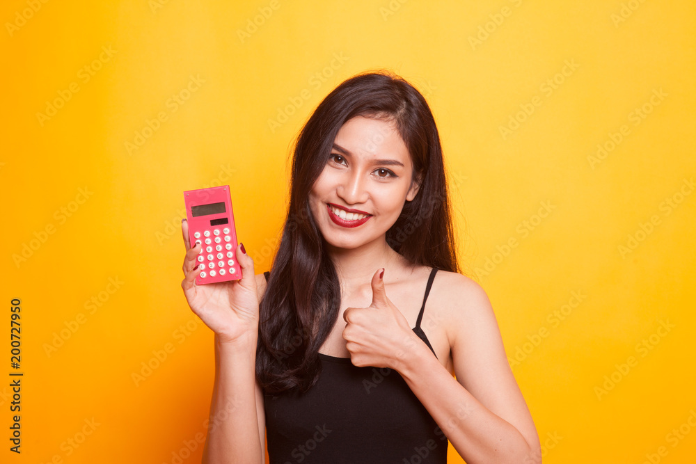 Asian woman thumbs up with calculator. Asian woman thumbs up with calculator.