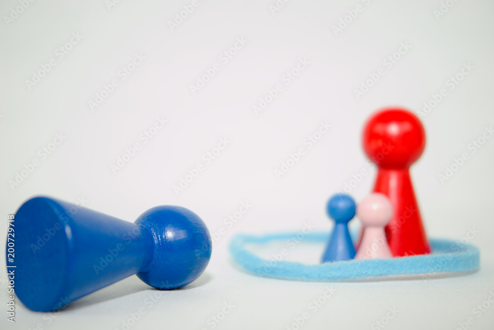isolated overturned blue wooden figure in the foreground, other blurred wooden figures in the background, systemic board, family therapie isolated overturned blue wooden figure in the foreground, other blurred wooden figures in the background, systemic board, family therapie