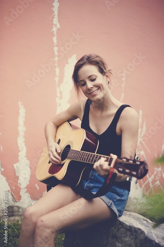 Caucasian woman is sitting and playing guitar classic