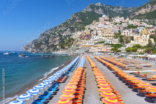 View of famous rows of blue and orange beach umbrellas on Positano Beach, Amalfi Coast, Italy. photo