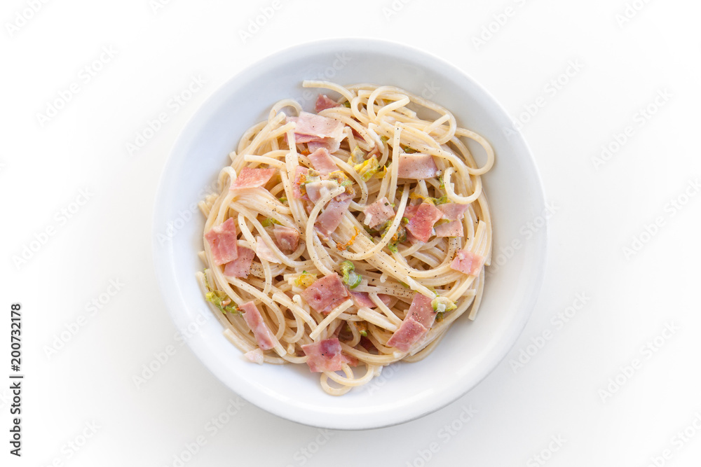spaghetti with ham and courgette flowers, top view of the plate on white background spaghetti with ham and courgette flowers, top view of the plate on white background