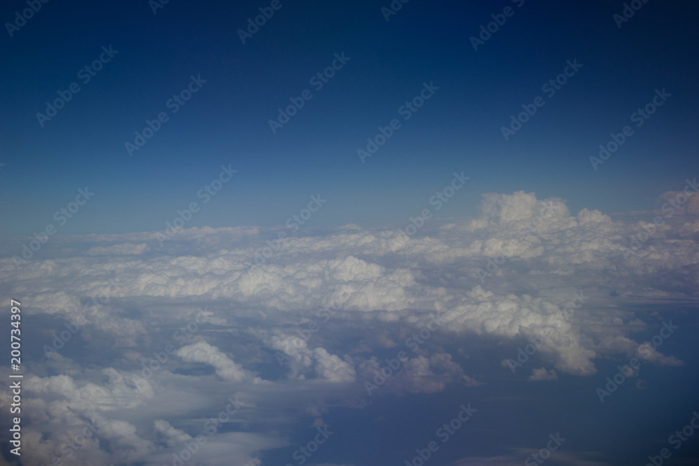 White clouds in the sky are photographed at the height of the flight of the aircraft
