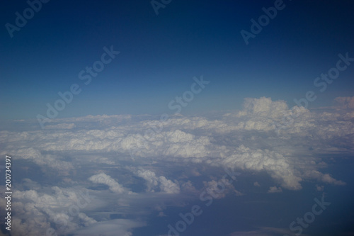 White clouds in the sky are photographed at the height of the flight of the aircraft