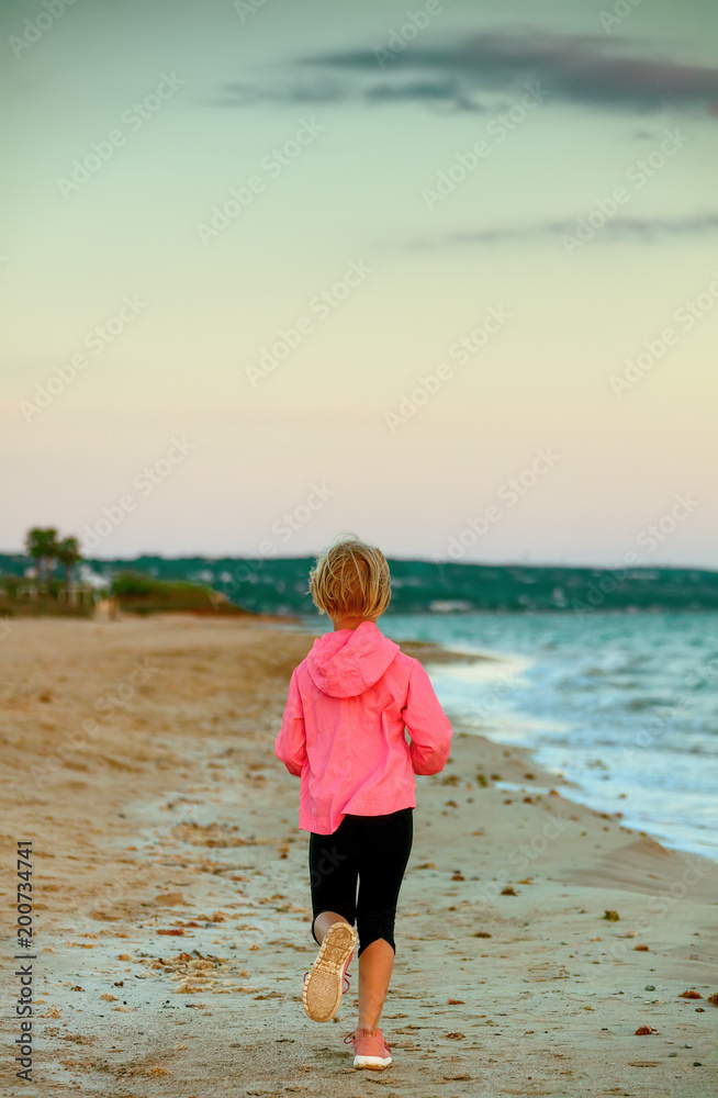 healthy child on seashore in evening running healthy child on seashore in evening running