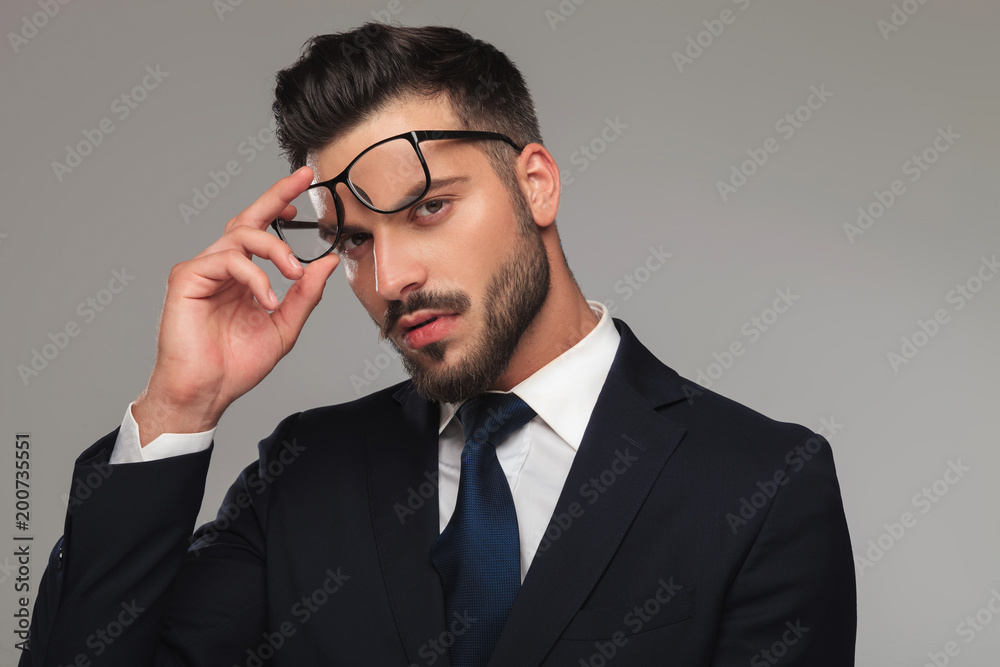 portrait of sensual businessman taking eyeglasses off portrait of sensual businessman taking eyeglasses off