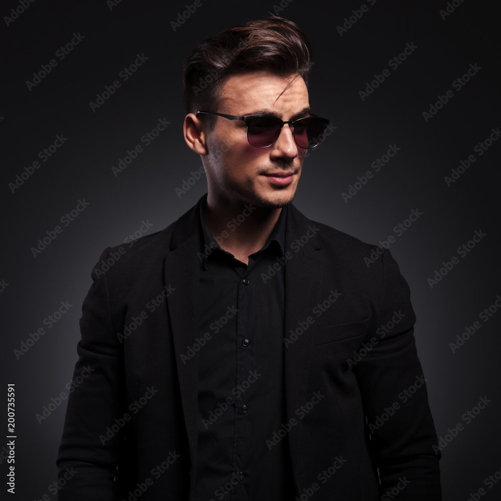 happy handsome fashion man with sunglasses looks to side happy handsome fashion man with sunglasses looks to side